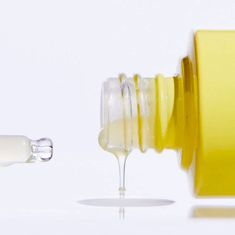 Close-up of a yellow skincare bottle dispensing serum with dropper for Korean skincare bundle deal