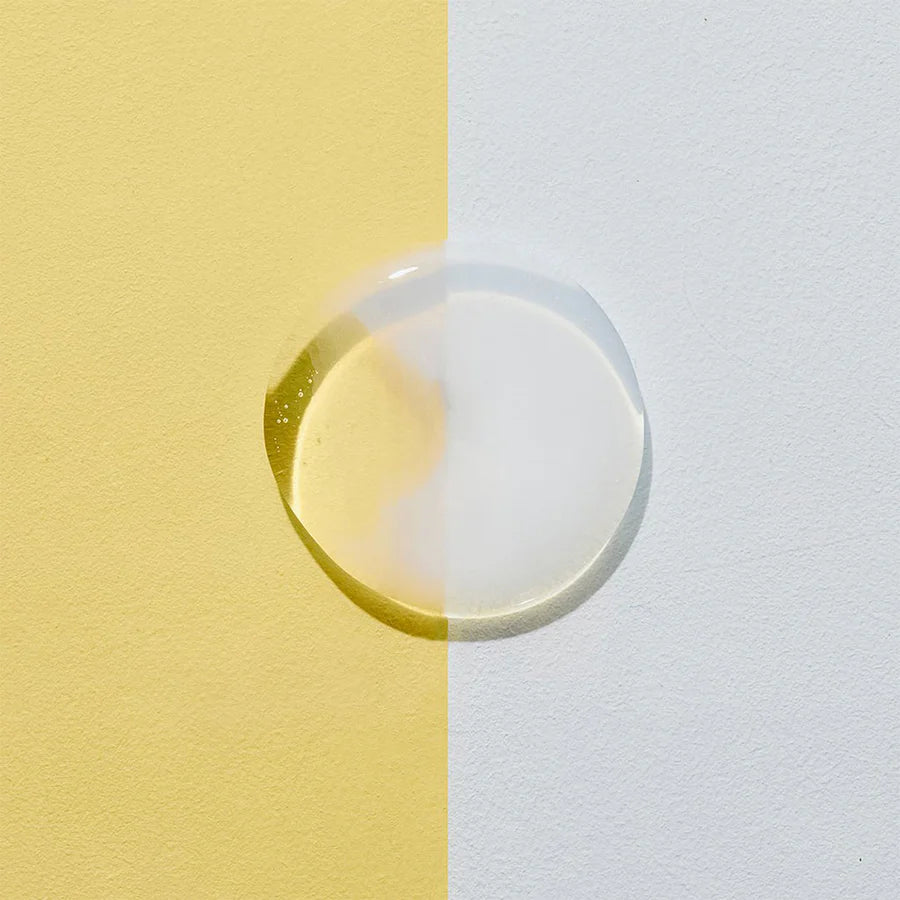 Clear droplet of Cosrx toner highlighting snail mucin essence for glowing skin on yellow and white background