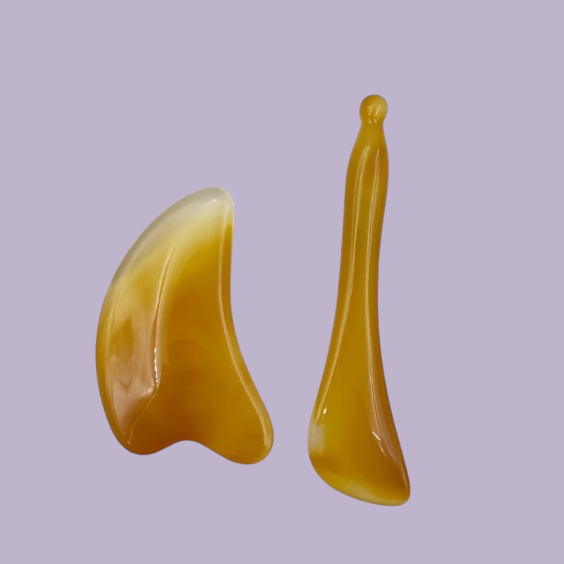 Zuzu Aura face sculpting massage set for skincare with smooth yellow massage tools on purple background