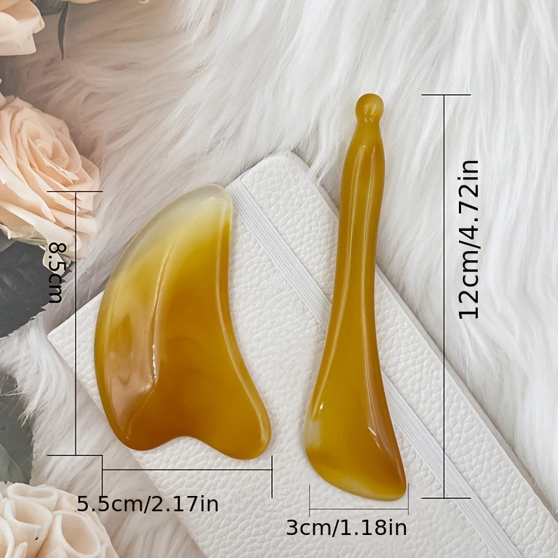 Zuzu Aura face sculpting massage set for skincare with two yellow massage tools on a white cushion