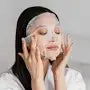 Woman applying Farm Stay aloe vera face mask sheet for soothing and moisturizing skin