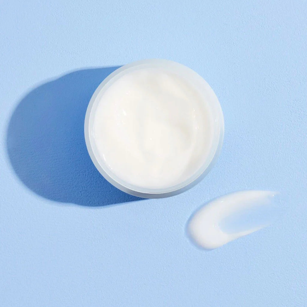 Cosrx hyaluronic acid moisturizer in open jar with cream swatch on blue background