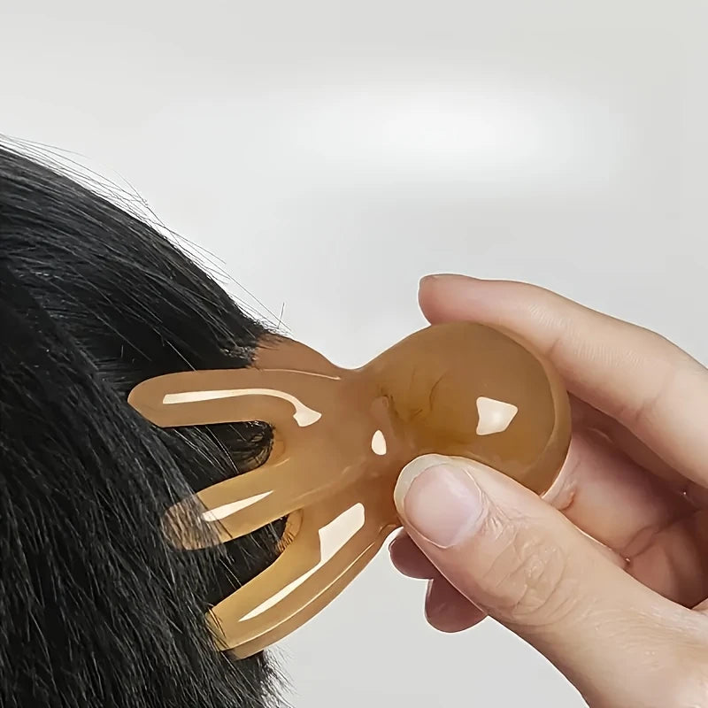Zuzu Aura octopus scalp massager held by hand brushing black hair for relaxation