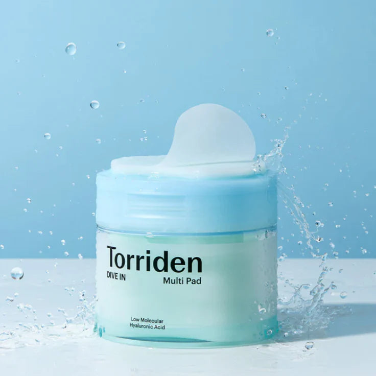 Torriden hyaluronic acid face pads for hydration in a clear blue jar with water splash background