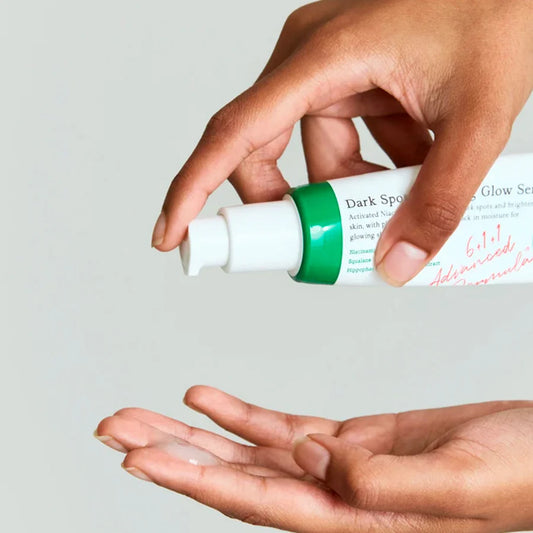 Zuzu Aura hands dispensing serum from bottle showing Korean skincare bundle deal product
