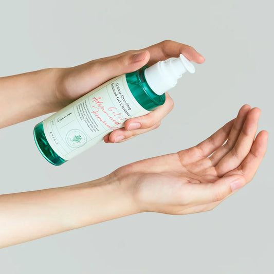 AXIS-Y quinoa gel cleanser bottle held in hand with pump dispenser for gentle skincare