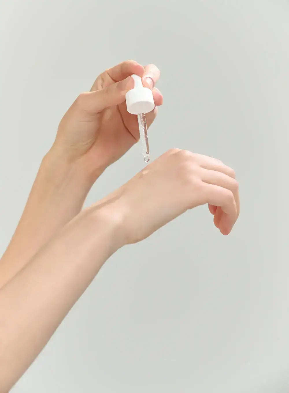 Applying Beauty Of Joseon rice arbutin serum onto the wrist with a dropper for skin brightening
