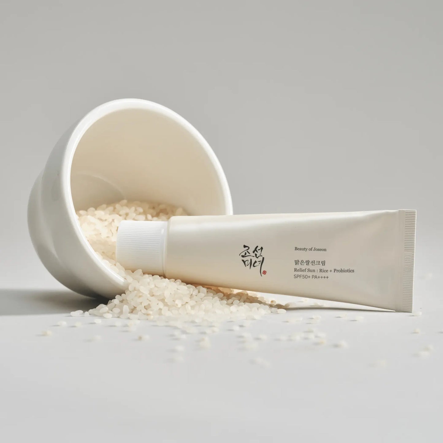 Beauty Of Joseon broad spectrum SPF 50 sunscreen in a tube with rice grains on a white background